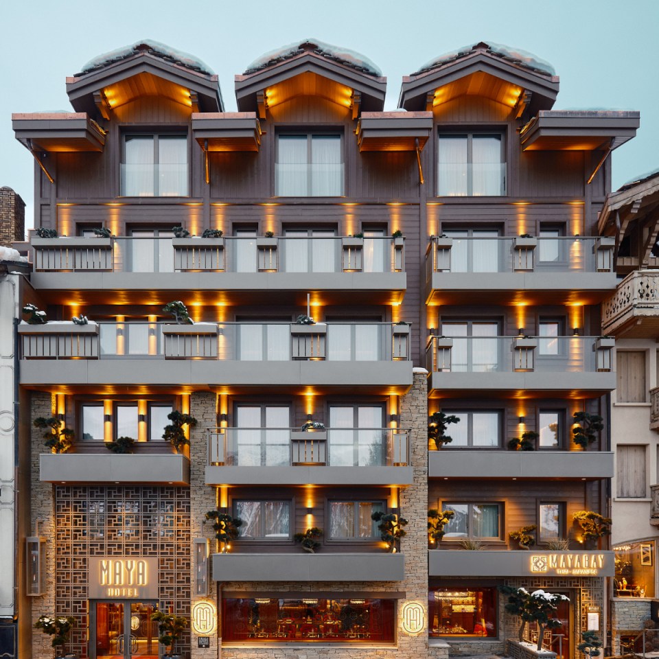 Maya Hotel Courchevel 1850 exterior showcasing luxurious alpine architecture against a snowy mountain backdrop