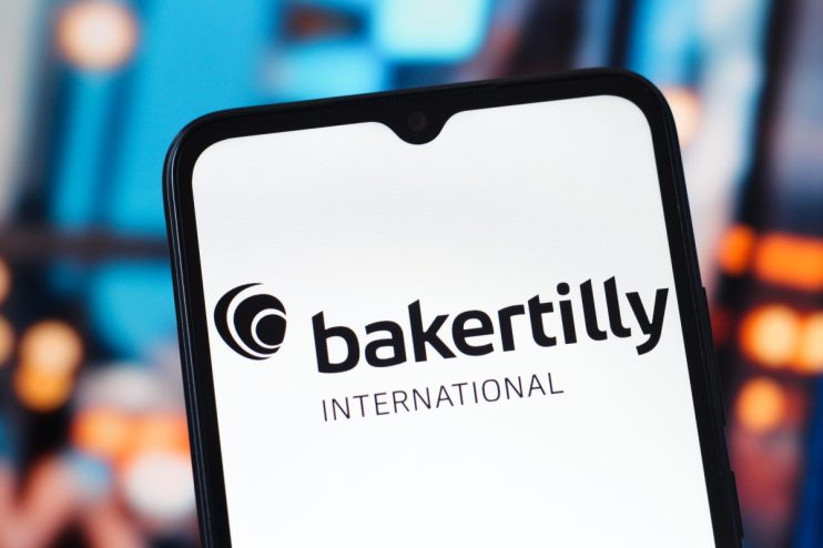 Baker Tilly office exterior with company logo prominently displayed on the building facade, under a clear blue sky.