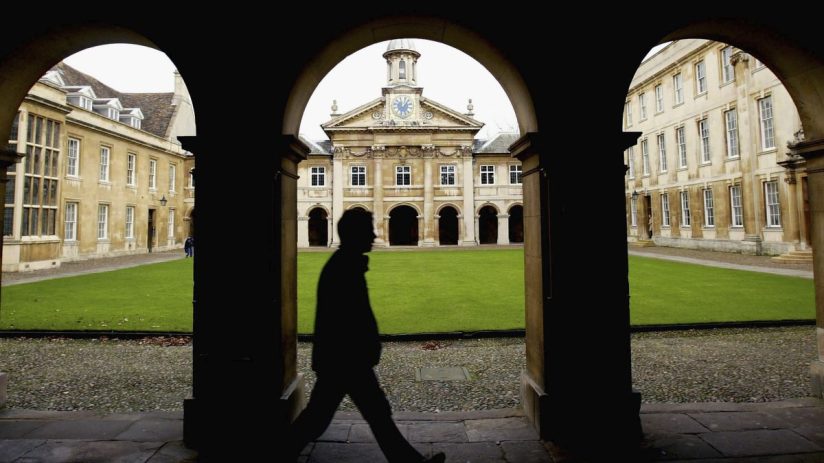 Cambridge University graduates gathered in formal attire during a crisis discussion on campus
