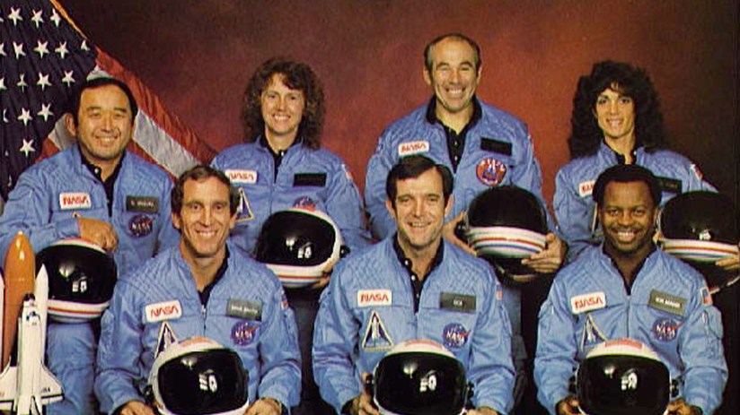 Space Shuttle Challenger exploding mid-air after launch, with smoke trails visible, highlighting the tragic 1986 space dis...