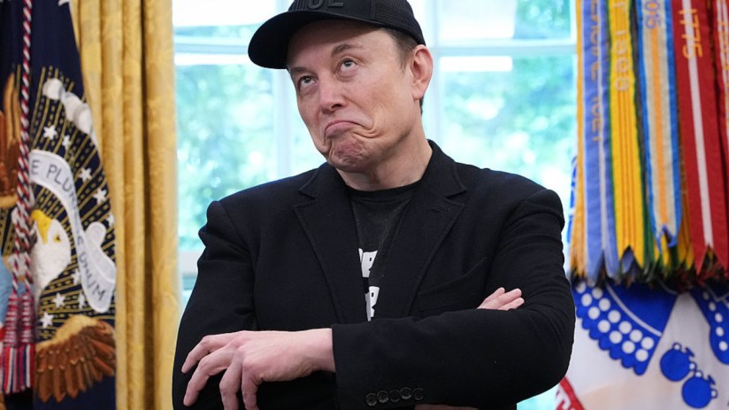 Elon Musk speaking at a tech conference, wearing a suit, with a futuristic backdrop highlighting space exploration themes