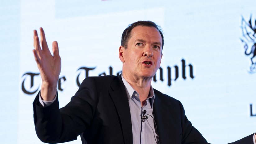 George Osborne speaking at a business conference, wearing a suit and tie, addressing economic policies and financial strat...