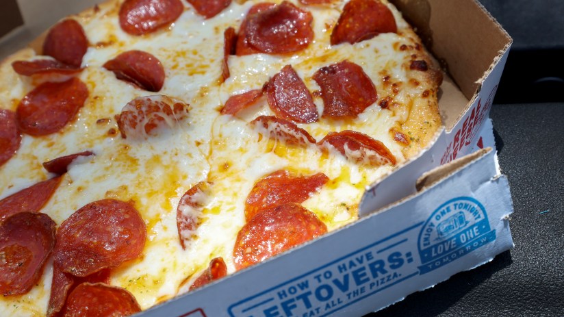 Delicious junk food pizza with melted cheese, pepperoni, and colorful toppings, capturing the essence of indulgent comfort...