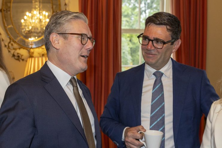 Keir Starmer and Andy Burnham discussing policy strategies during a conference meeting, highlighting political collaboration.