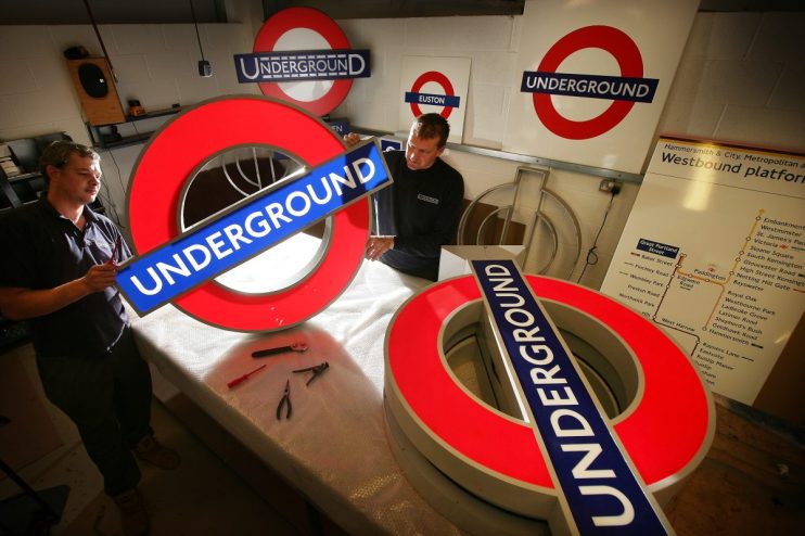 London Underground roundel symbol at a station entrance, iconic blue and red design representing public transit in the UK ...