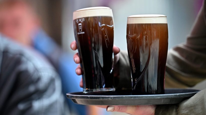 Pints of Guinness on a bar counter in UK pub, highlighting traditional British pub culture and popular beer choice