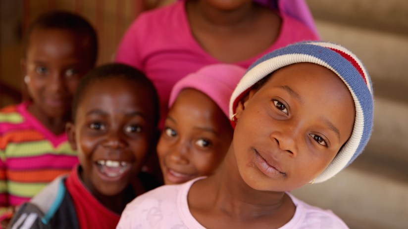 South African children playing outdoors in a lively community setting, showcasing diverse cultural backgrounds and vibrant...