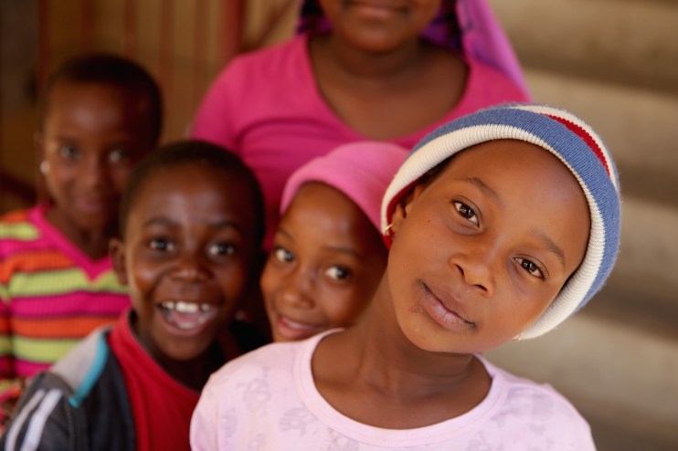 South African children playing outdoors in a lively community setting, showcasing diverse cultural backgrounds and vibrant...