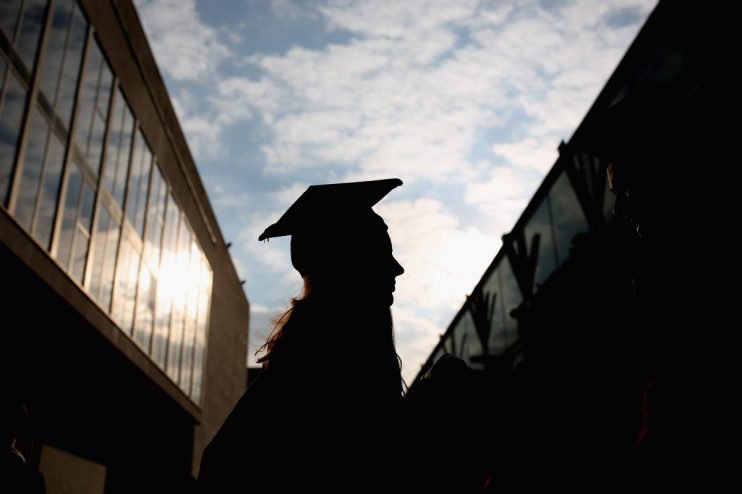 UK university graduate in cap and gown holding diploma at a campus ceremony, celebrating academic achievement and success