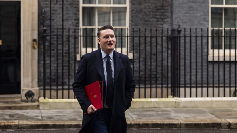 Wes Streeting speaking at a podium during a public event, wearing a suit and tie, addressing key issues in the general cat...