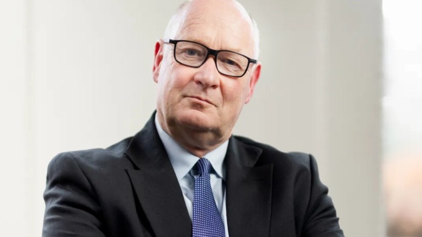 Business professional in a suit reviewing financial reports at a desk, highlighting current economic trends and data analysis
