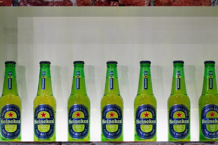 Heineken alcohol-free beer bottle on a table, showcasing its label and branding in a news feature on non-alcoholic beverages