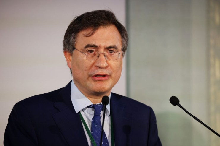 Chris Hohn, founder of The Childrens Investment Fund (TCI), at a business conference podium delivering a keynote speech