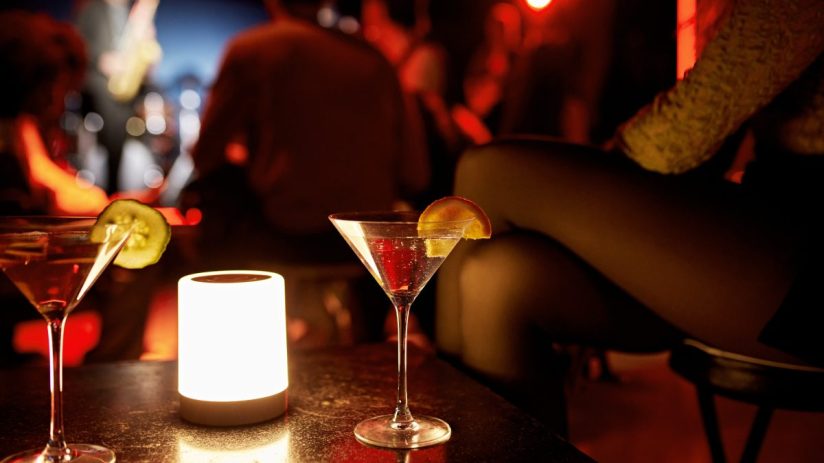 Chic cocktail bar interior with stylish seating, ambient lighting, and an array of colorful drinks on display