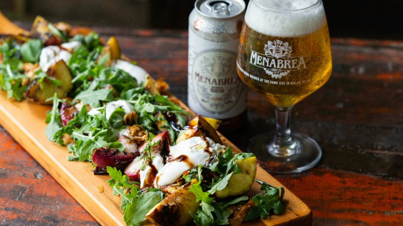 Menabrea brewery exterior showcasing historic architecture and bustling street scene in a vibrant business district.
