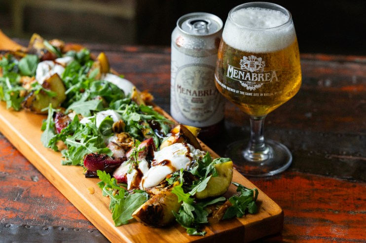 Menabrea brewery exterior showcasing historic architecture and bustling street scene in a vibrant business district.