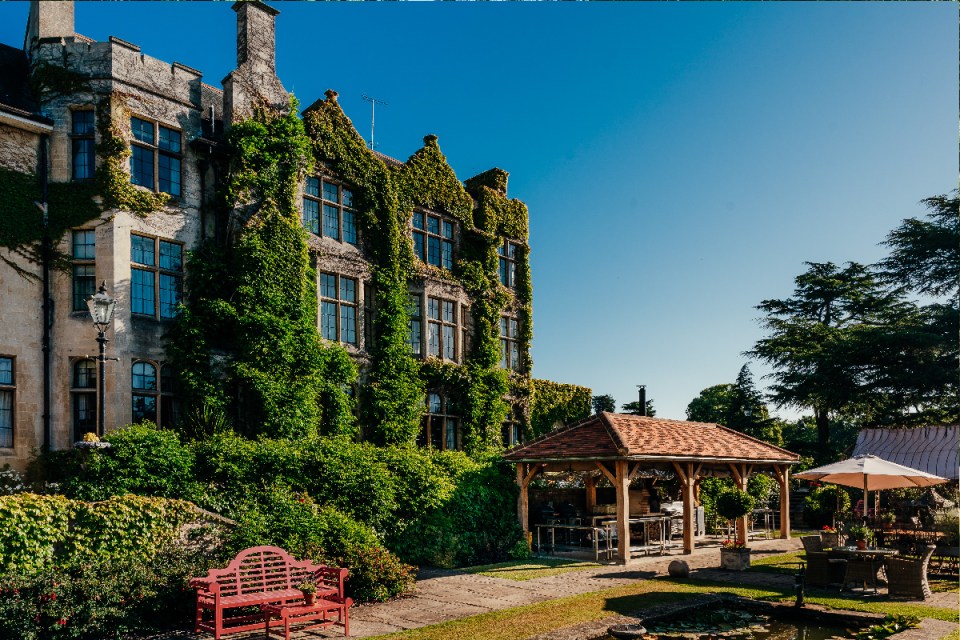 Pennyhill Park luxury hotel exterior surrounded by lush gardens, showcasing elegant architecture and serene natural setting