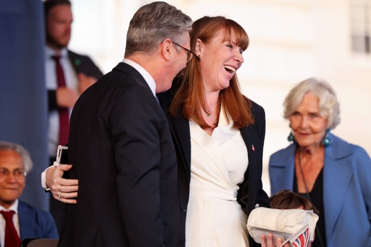 Starmer and Rayner embrace warmly, highlighting unity and camaraderie in a political setting, symbolizing partnership and ...