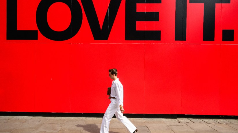 Person walking on a busy city street, surrounded by modern skyscrapers, showcasing urban lifestyle and daily commute.