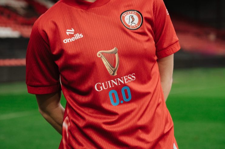 Bristol City WFC player Bigault in action, holding Guinness cup, highlighting team spirit and sports achievements