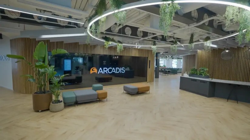 Arcadis office building exterior with company logo, modern architecture against a clear blue sky, reflecting corporate pre...