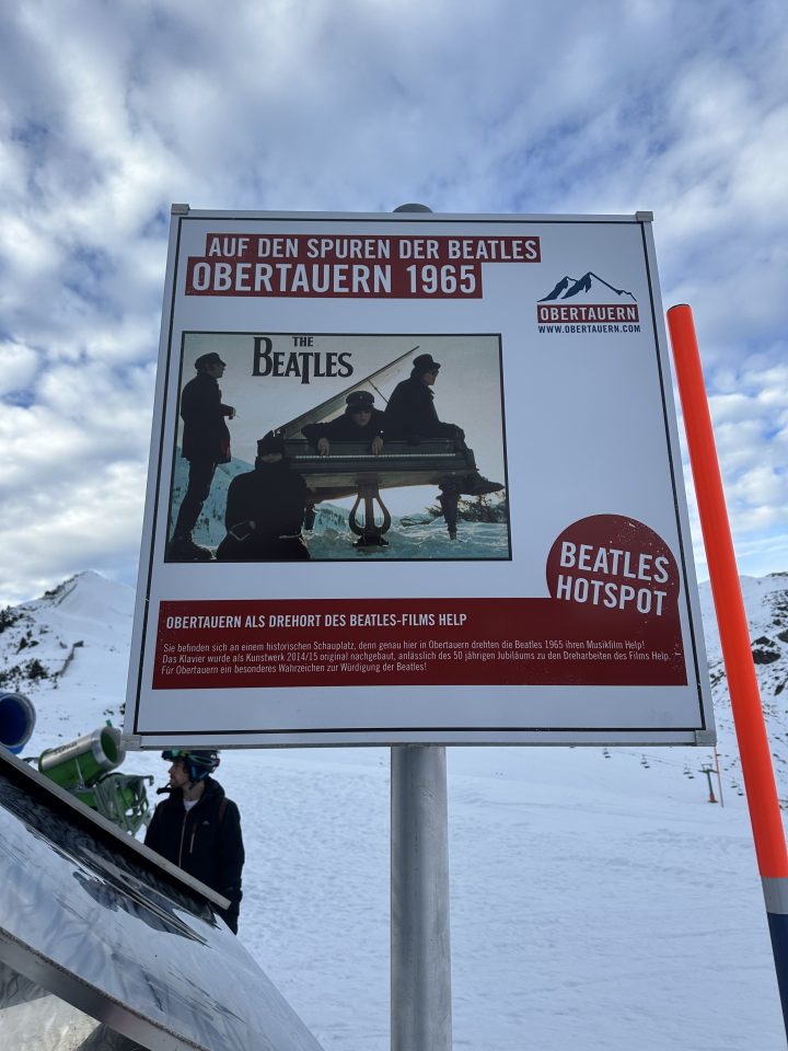 The Beatles playing piano in Obertauern during filming of Help! in 1965, capturing a historic music moment.