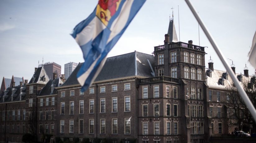 Dutch parliament building with flags and people, symbolizing political discussions, governance, and legislative activities