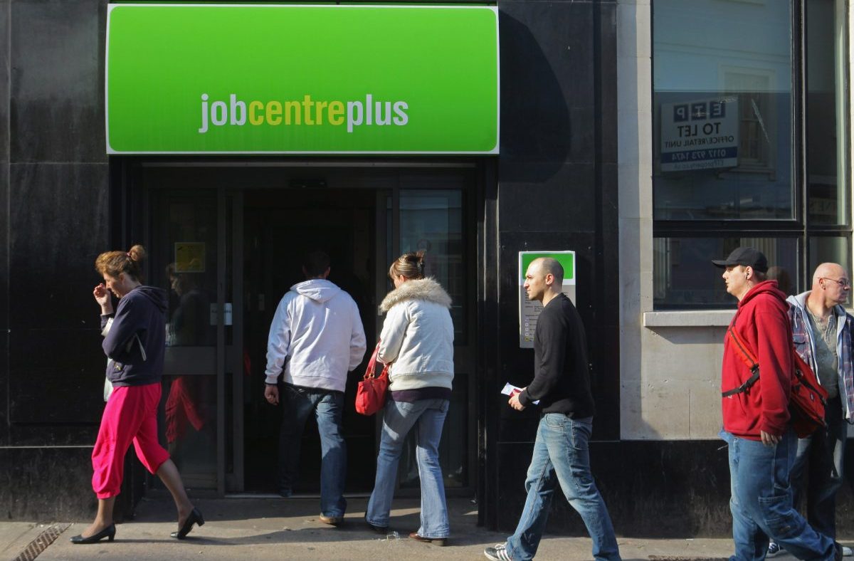 People waiting outside a job centre, highlighting unemployment issues and job search challenges in the current economy.
