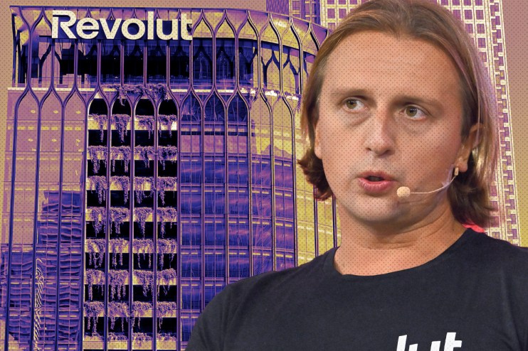 Revolut app interface on smartphone screen showcasing financial transaction features, set against a modern office background.