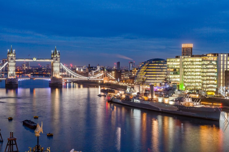 Tower Bridge against a clear sky, viewed from Halkin with London skyline in the background, iconic architecture in focus.
