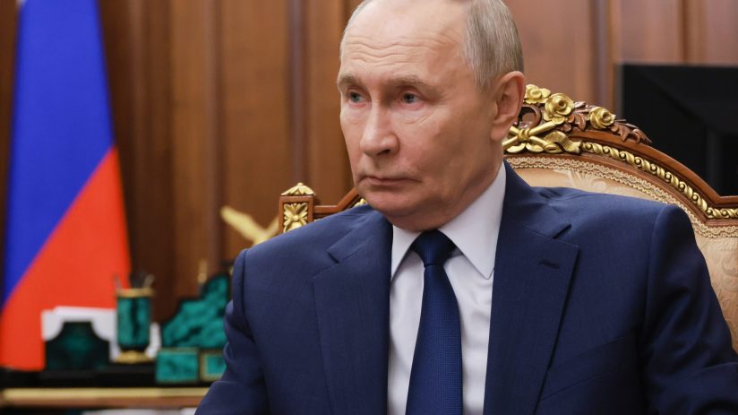 Vladimir Putin delivering a speech at an official event, addressing international relations and economic policies.