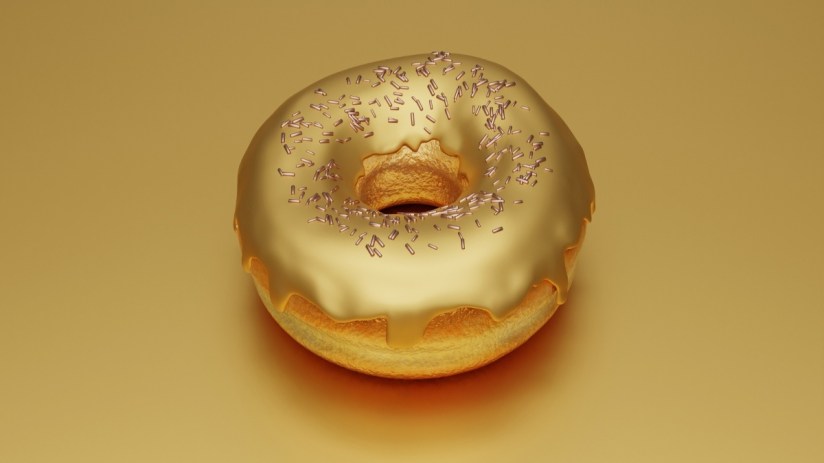 Golden donut on a white plate, symbolizing luxury and indulgence, with a gleaming glaze reflecting ambient light.