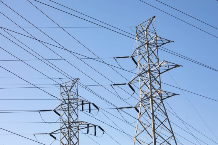 Pylons standing tall against a clear sky following Engies acquisition of UK Power Networks, symbolizing energy sector growth.