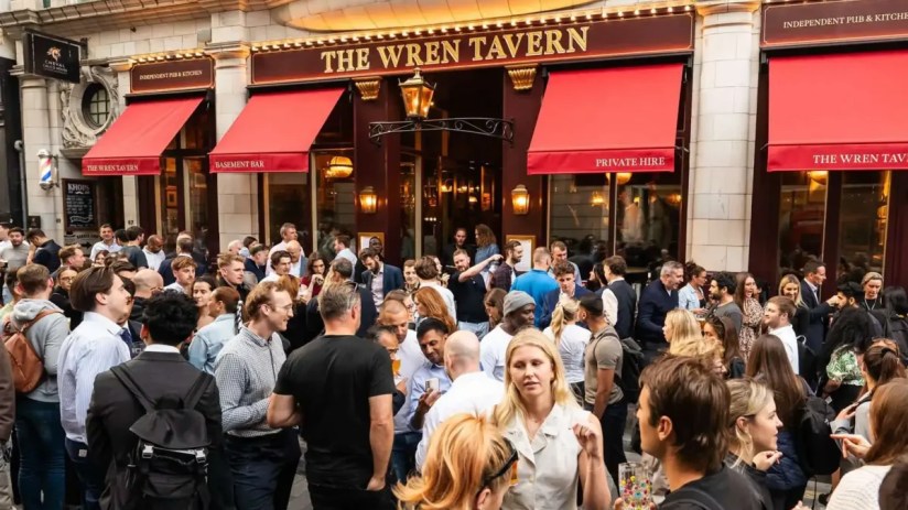 The Wren Pub exterior showcasing its historic architecture with patrons enjoying outdoor seating on a lively street.