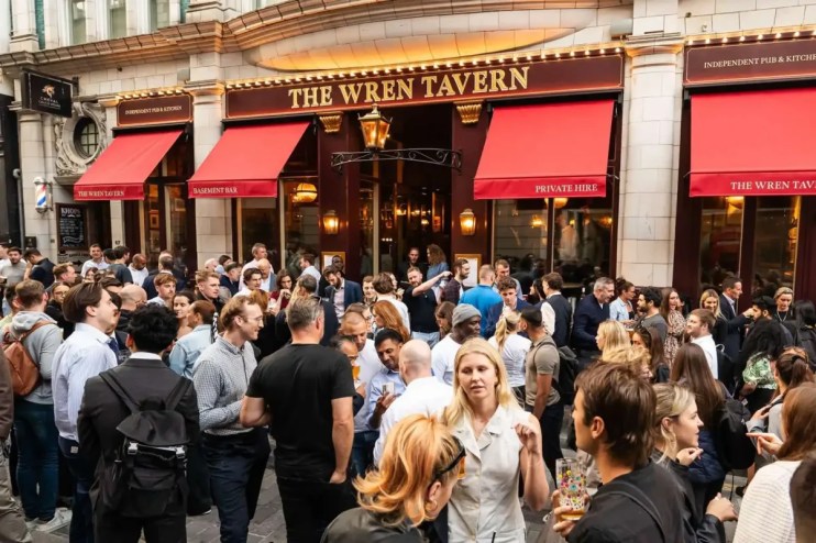 The Wren Pub exterior showcasing its historic architecture with patrons enjoying outdoor seating on a lively street.