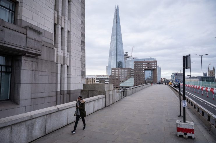 London Bridge eerily empty during Covid lockdown with overcast skies and historic architecture visible in the background.
