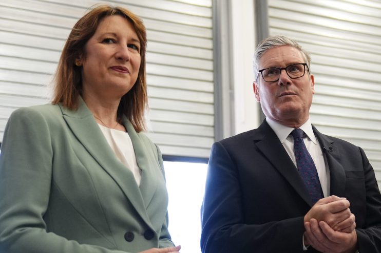 Rachel Reeves and Keir Starmer engaged in discussion during a political event, highlighting leadership and economic strate...