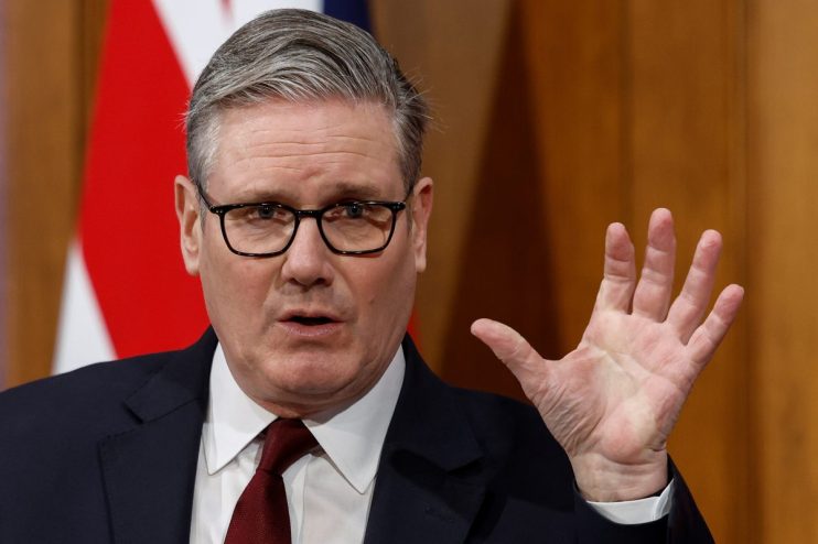 Keir Starmer stands with a British flag, highlighting political leadership and national pride in a business news context.