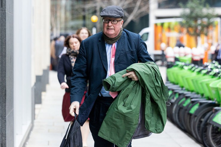 Crispin Odey entering court in a formal suit, capturing a pivotal moment in a high-profile legal proceeding.
