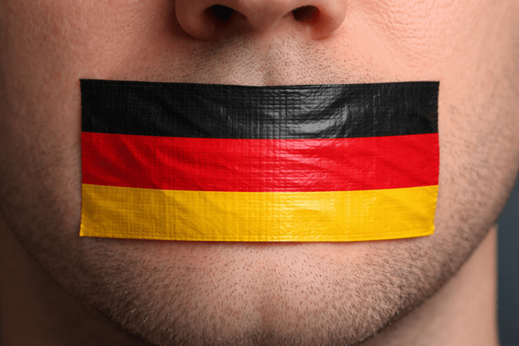 German flag with speech bubble symbolizing freedom of speech in Germany on a news website backdrop