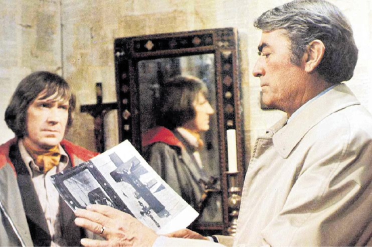 Dramatic scene from The Omen featuring a suspenseful moment with intense expressions and moody lighting.