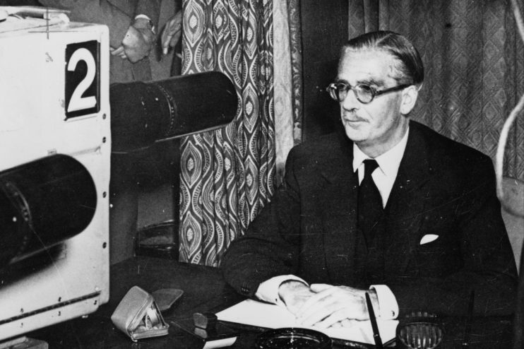 British Prime Minister Anthony Eden during the Suez Crisis, addressing the nation with a stern expression and formal attire.