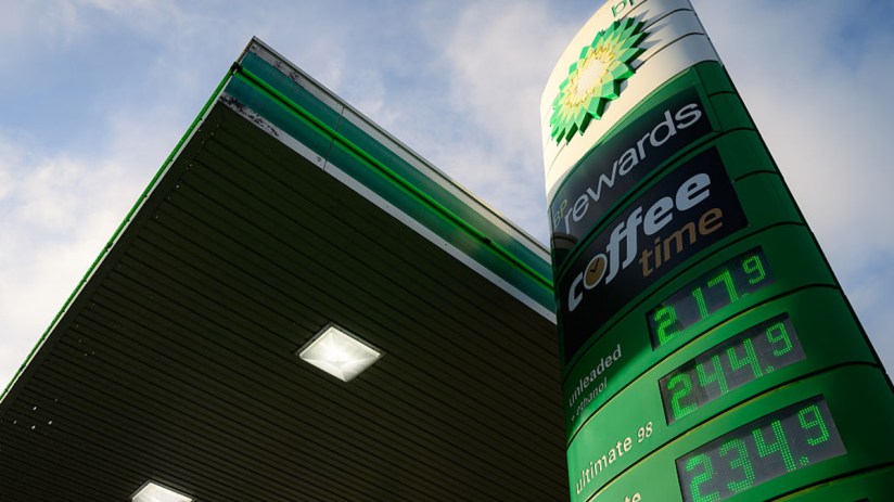 BP petrol station with green and yellow branding, multiple fuel pumps, and a canopy, set against a clear blue sky.