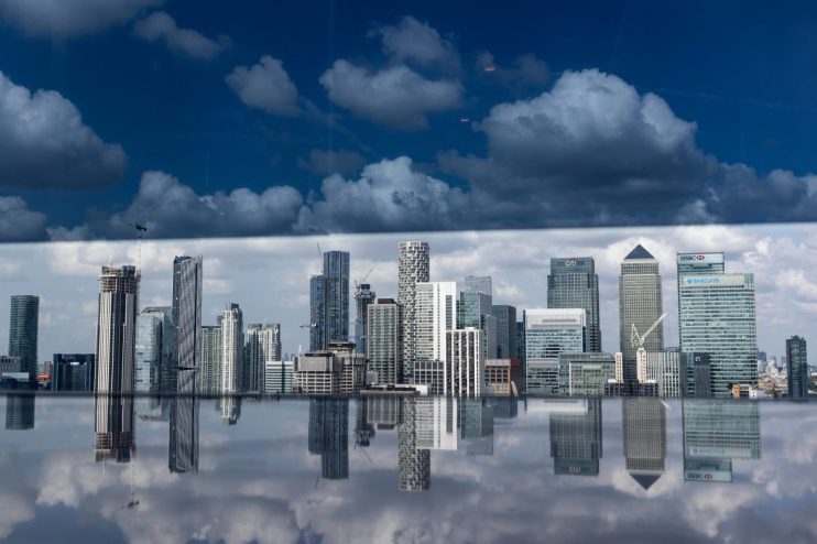 Canary Wharf skyline featuring modern high-rise buildings under a clear sky, highlighting Londons financial district.