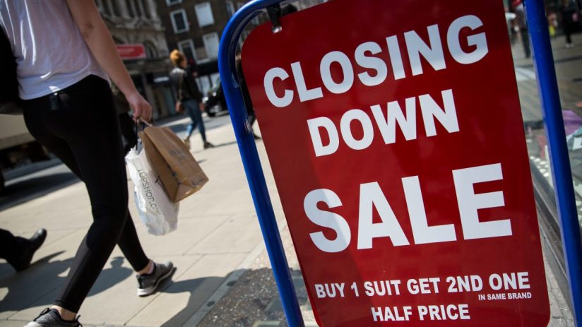 Closed sign hanging on small business door, symbolizing temporary closure or operational pause amid challenging market con...