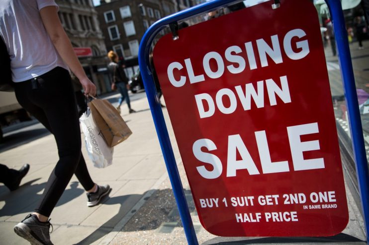 Closed sign hanging on small business door, symbolizing temporary closure or operational pause amid challenging market con...