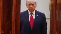Donald Trump speaking at April event, wearing a suit and tie, with an expressive gesture and a serious facial expression