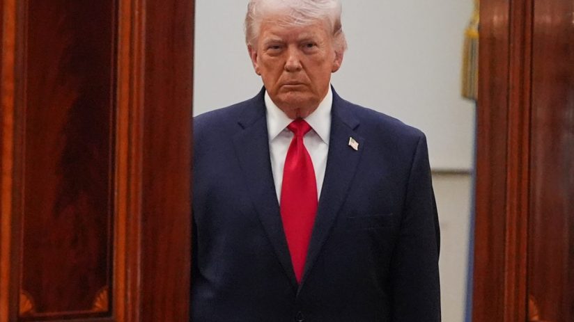 Donald Trump speaking at April event, wearing a suit and tie, with an expressive gesture and a serious facial expression