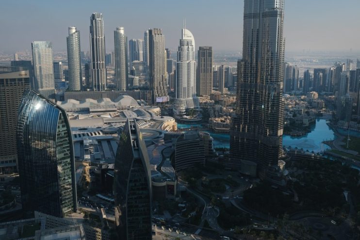Dubai skyline featuring iconic skyscrapers and modern architecture under a clear blue sky, showcasing the citys urban land...