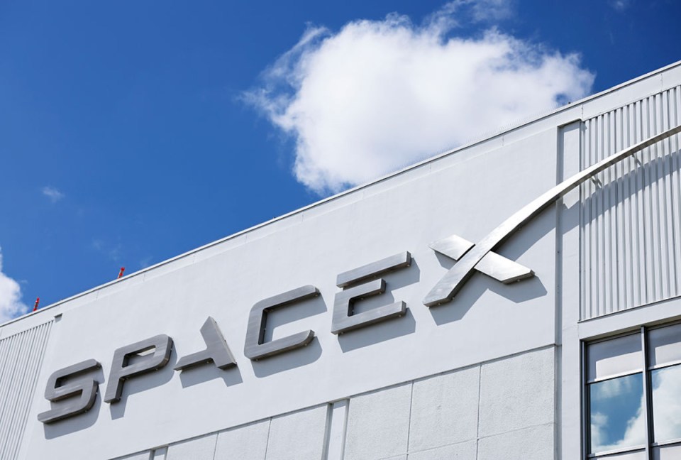 Elon Musk discussing SpaceXs potential stock market listing at a press conference, highlighting the companys achievements.